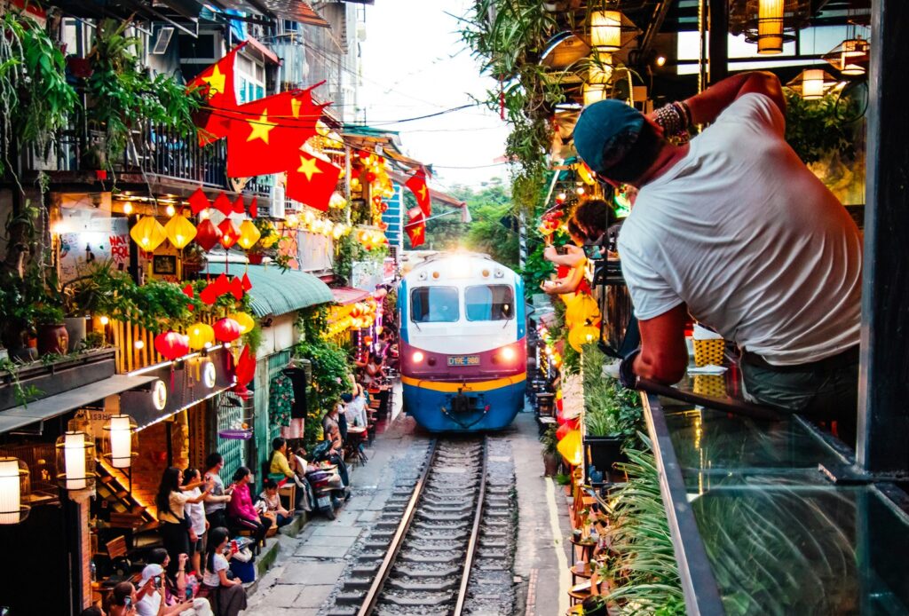 A train traveling down train tracks next to a crowd of people